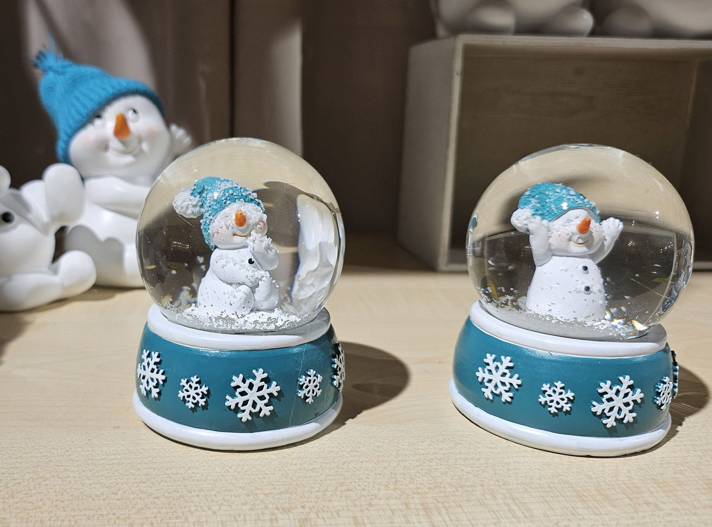 Süße Mini - Schneekugel Schneemann Hand am Mund auf Sockel türkis weiße Schneeeflocke B: 45mm - Schneekugelhaus